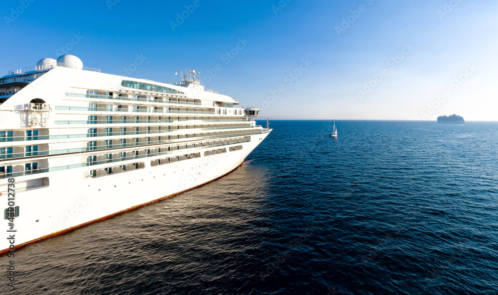 Naklejka premium Cruise ship and a tiny yacht in mediterranean sea