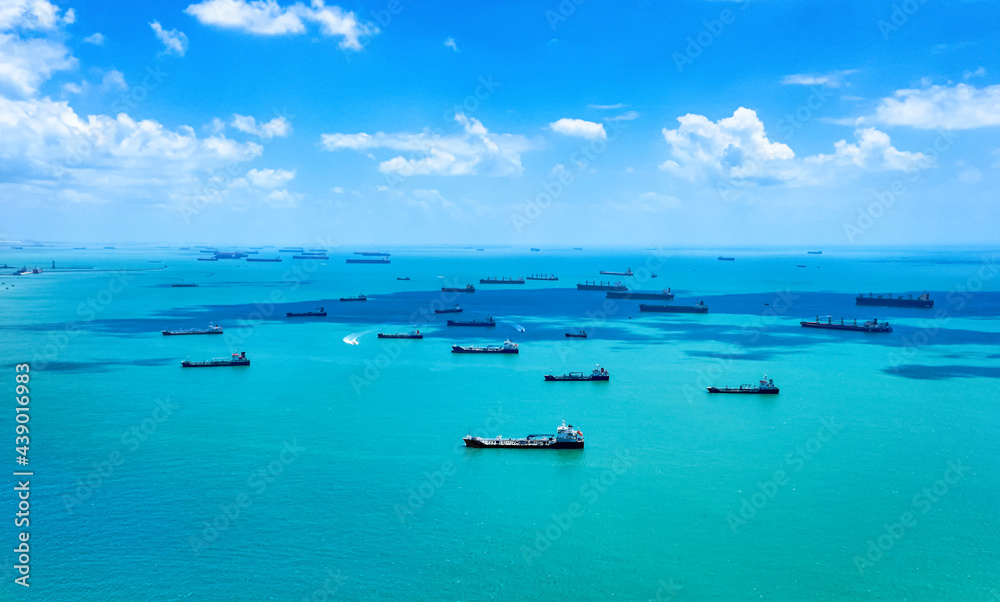 Aerial view of container ships in Singapore Strait. Airplane shot. Cargo ships anchored in the road, waiting to enter the busiest port in region. 