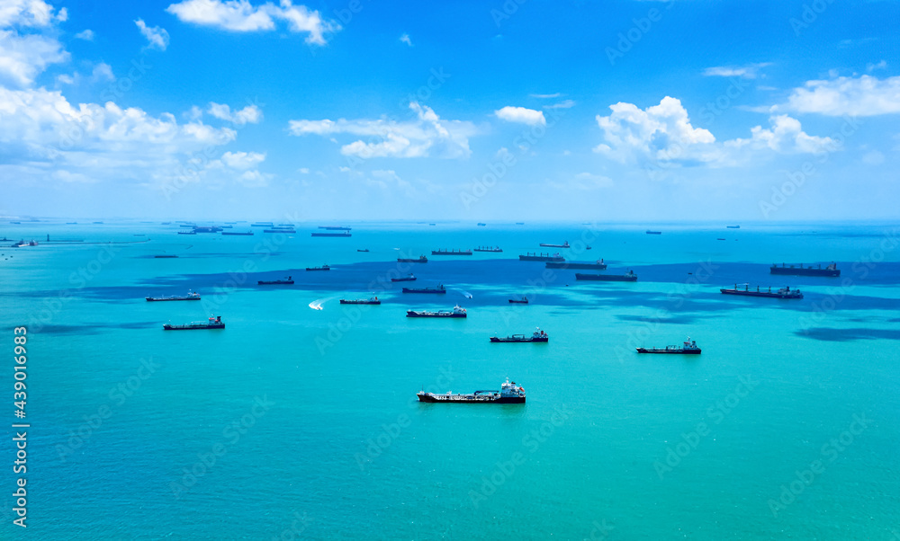 Aerial view of container ships in Singapore Strait. Airplane shot. Cargo ships anchored in the road, waiting to enter the busiest port in region.