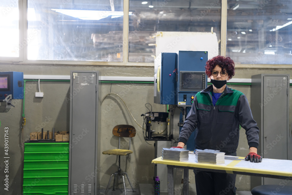 woman working in a modern factory and preparing materia for a CNC machine. woman working in a modern factory and preparing materia for a CNC machine.