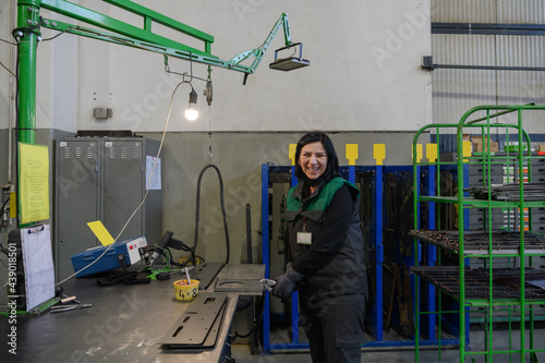 a woman working in the modern metal production and processing industry welds the product and prepares it for a cnc machine