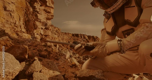 Unrecognizable astronaut analyzing soil of Mars