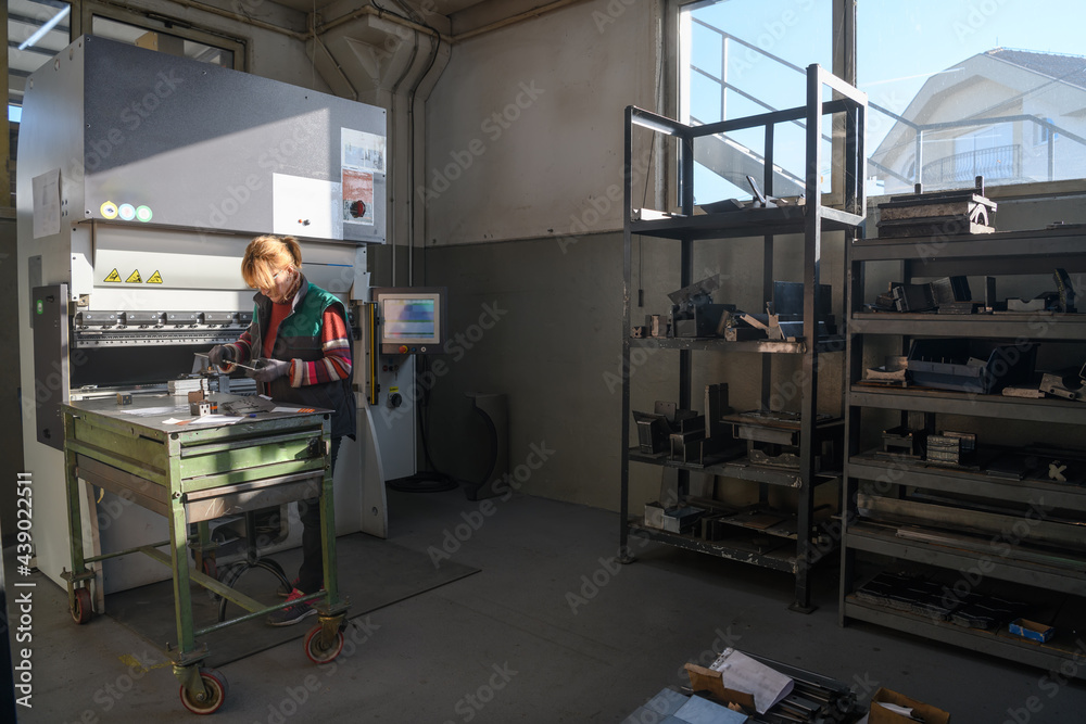 woman working in a modern factory and preparing materia for a CNC machine. woman working in a modern factory and preparing materia for a CNC machine.