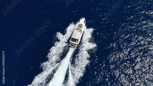 Aerial drone top down photo of luxury yacht with wooden deck cruising in the Aegean deep blue sea, Greece
