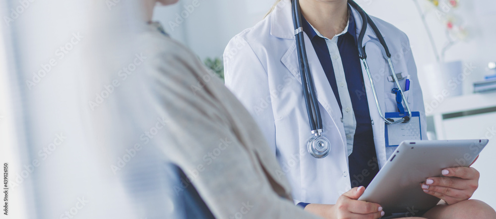 Doctor and patient discussing something while sitting at the table . Medicine and health care concept Doctor and patient discussing something while sitting at the table . Medicine and health care concept