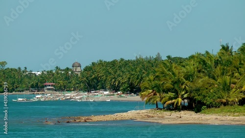 Boats laying on sand beach with palm trees in background	 photo