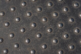 Closeup of a used metal plate with studs as a crossing marker for blind people. Closeup of a metal plate with studs as a crossing marker for blind people. 
The plate is in the sidewalk of a Dutch city