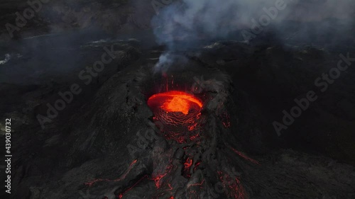 Aerial footage of an icelandic volcano erupting in 2021 in Reykjanes peninsula, shot at dusk with contrast with black lava landscape and red hot lava. High quality 4k footage