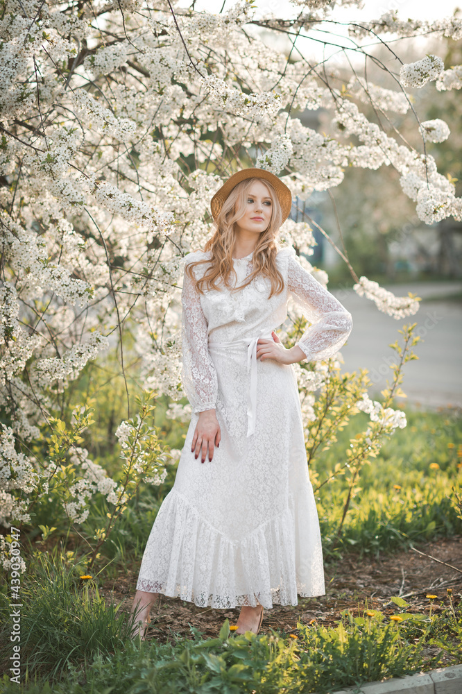 A beautiful girl in a hat among the flowering trees 2723. A beautiful girl in a hat among the flowering trees 2723.