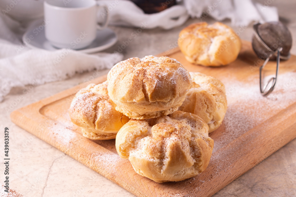 Profiteroles, a sieve with powdered sugar, breakfast cups. Profiteroles, a sieve with powdered sugar, breakfast cups.
