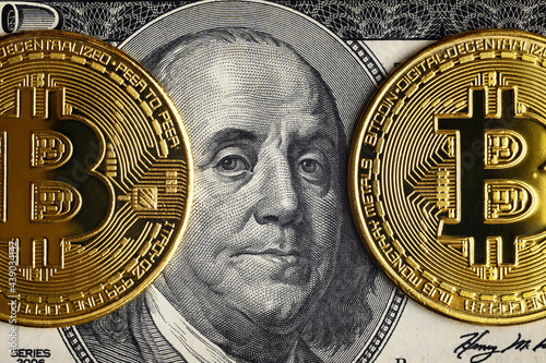 Bitcoin vs US dollar, gold bit coins on 100 dollar bill photo
