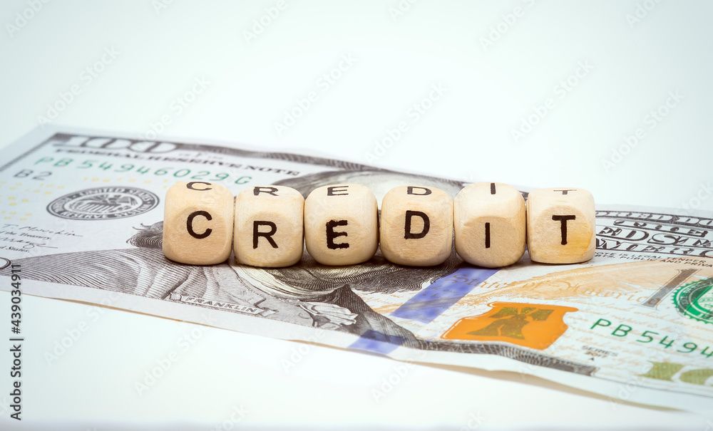 Word credit on wooden cubes on a hundred dollar bill Word credit on wooden cubes on a hundred dollar bill