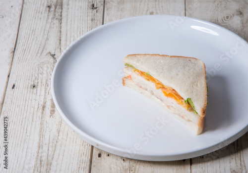 Sandwiches in white plates on wooden floor