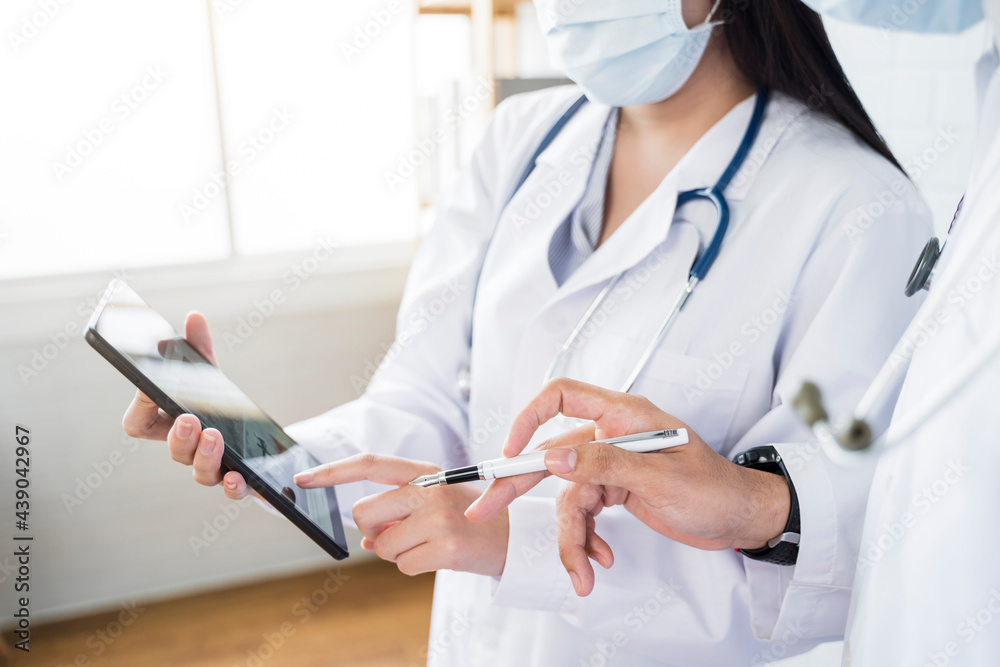 Close up Asian Medical healthcare doctor colleague teamwork working together examine diagnosing discussing using tablet wearing surgical mask work at home modern office online technology communication Close up Asian Medical healthcare doctor colleague teamwork working together examine diagnosing discussing using tablet wearing surgical mask work at home modern office online technology communication