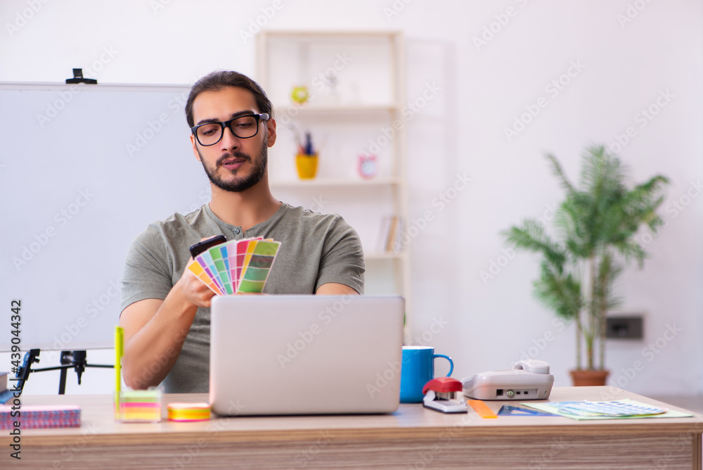 Young male designer working in the office Young male designer working in the office
