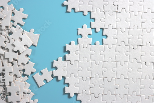 plain blue background with disassemble incomplete white jigsaw puzzle for your background or your content. photo