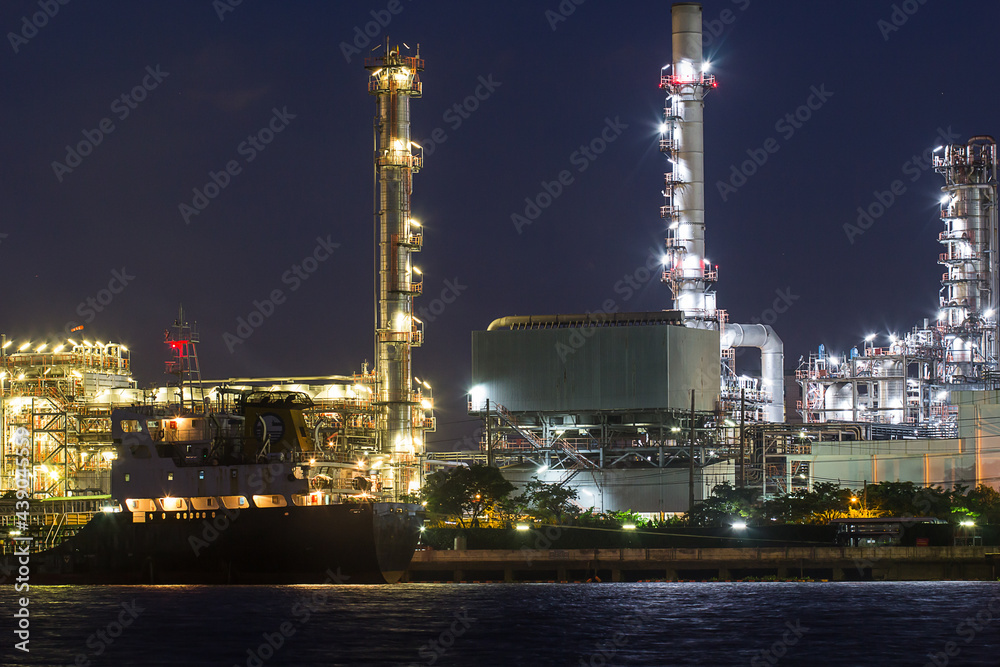 Oil refinery river side with boat supply tank