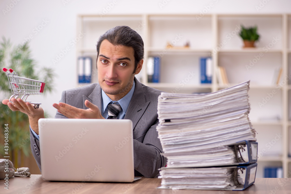 Young male employee in e-commerce concept Young male employee in e-commerce concept