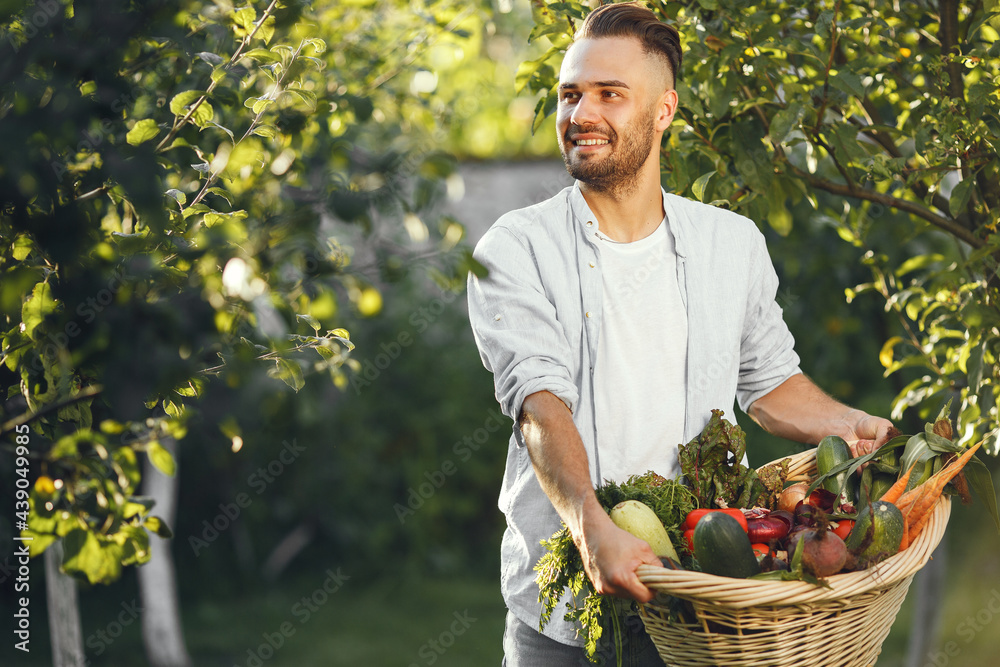 Fototapeta premium Portrait of smiling farmer holding vegetables basket