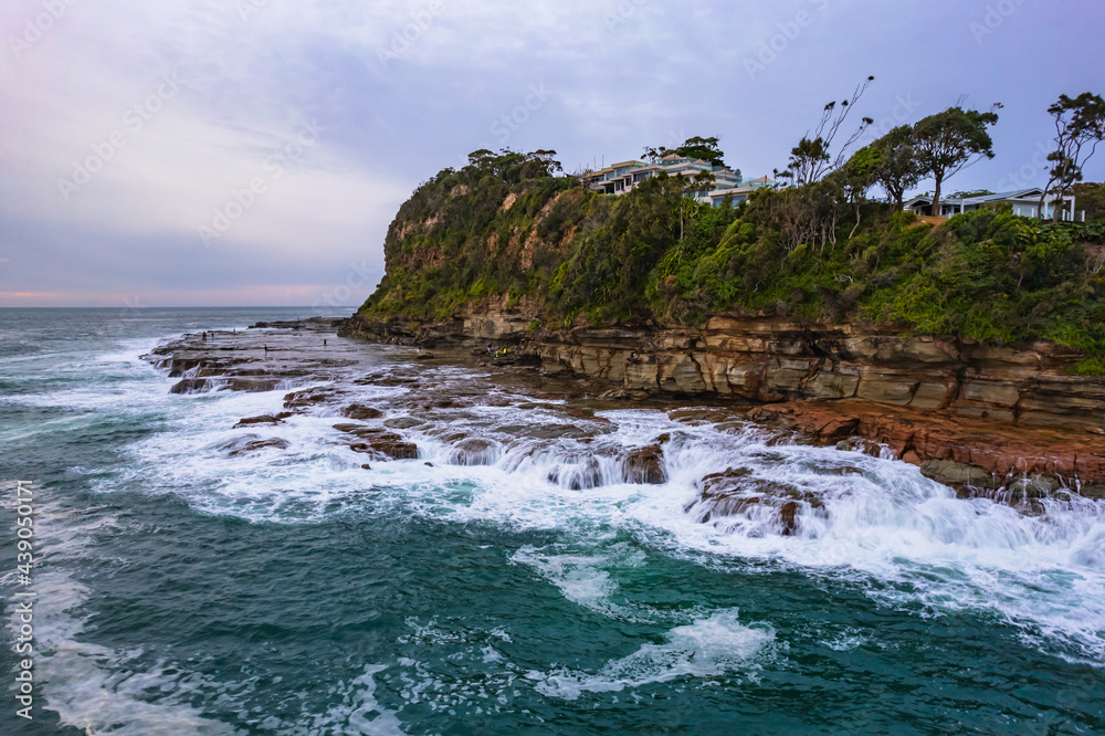 Aerial sunrise seascape and rock platform with cloud cover