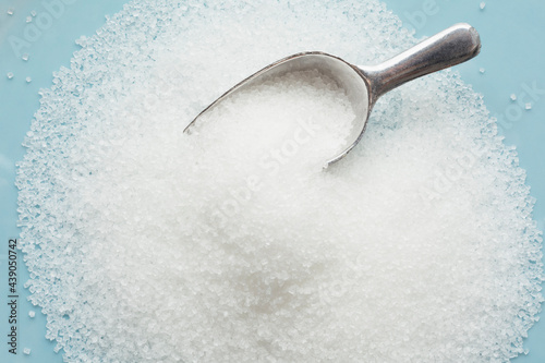 Studio shot of heap of sugar and scoop
