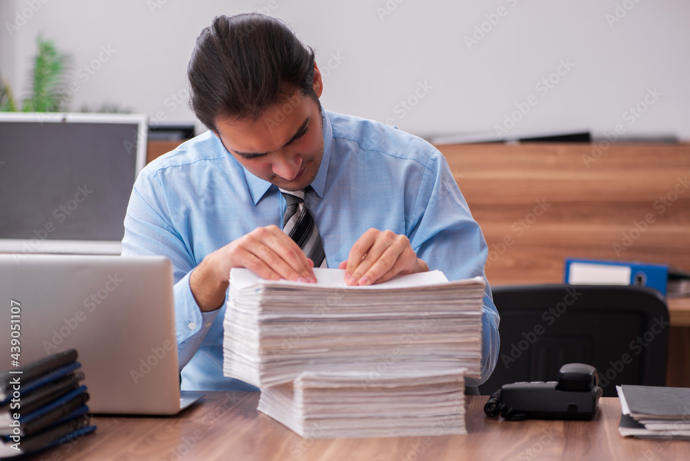 Young male employee unhappy with excessive work Young male employee unhappy with excessive work