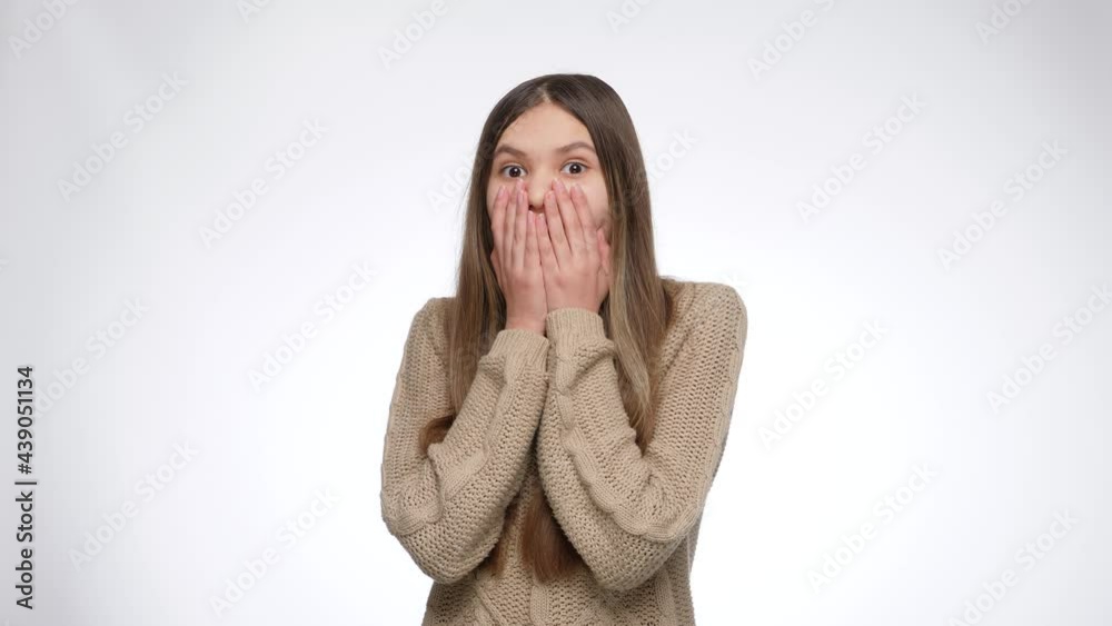 Amazed or shocked girl opens moth and closes it with hands Amazed or shocked girl opens moth and closes it with hands
