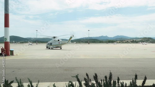 Slow motion video of an helicopter taking-off from an airport runway. OlbiaAirport is the second largest airport in Sardinia, Italy. photo