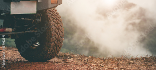 Part of an off-road vehicle on a dirt road with warm light. Adventure concept.Tire off-road on mud photo