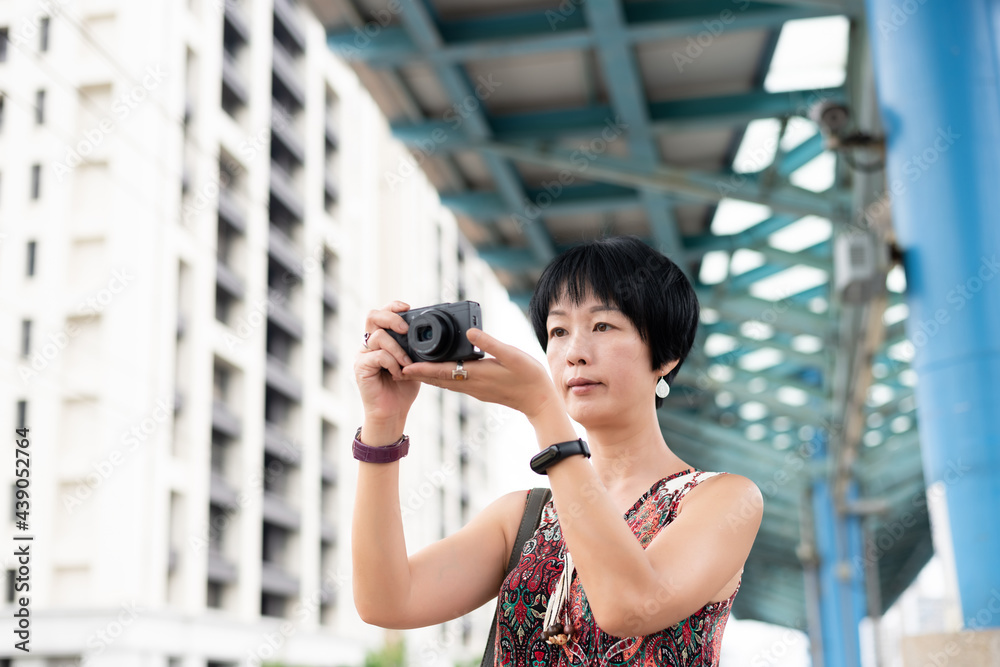 mature Asian woman using digital camera