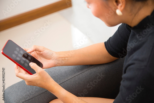 Close up of woman hand using smartphone  browsing internet  checking social media  sitting on the sofa in living room.