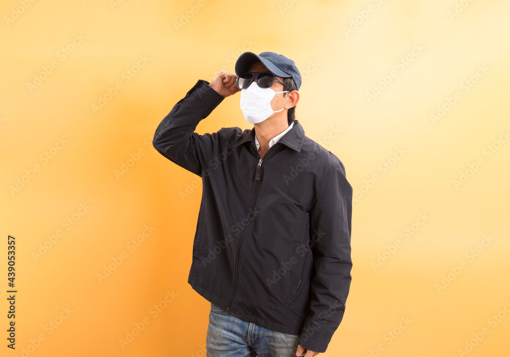 Asian delivery man in protective mask stand over pastel background. Coronavirus concept. Asian delivery man in protective mask stand over pastel background. Coronavirus concept.