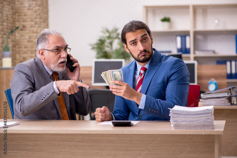 Two male employees in remuneration concept Two male employees in remuneration concept
