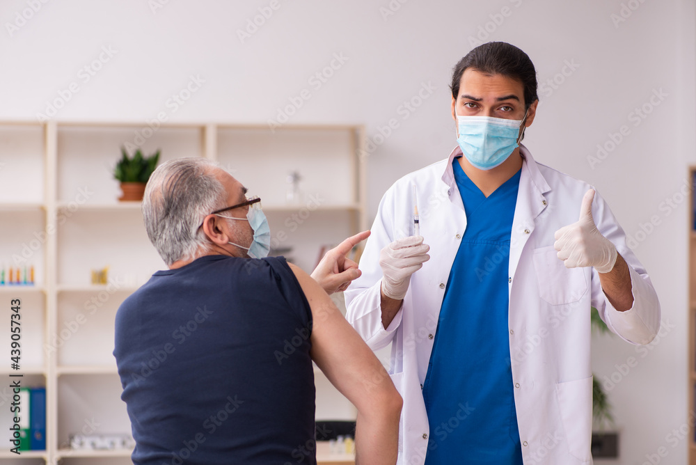Old man visiting young doctor in covid-19 vaccination concept Old man visiting young doctor in covid-19 vaccination concept