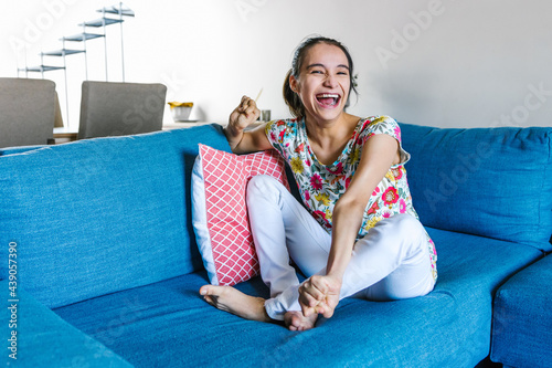 mexican disabled teen girl with cerebral palsy sitting on the couch at home in disability concept in Latin America photo