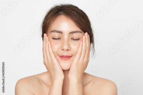 Beautiful Asian woman close eye touching her skin facial face care on white background. Beauty female with natural makeup and perfect skin.
