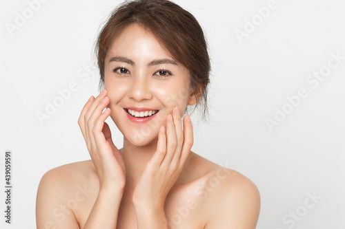 Beautiful Asian woman happy touching her skin facial face care on white background. Beauty female with natural makeup and perfect skin.