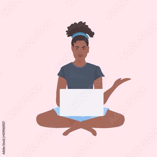 young woman sitting lotus pose working on laptop freelance concept full length