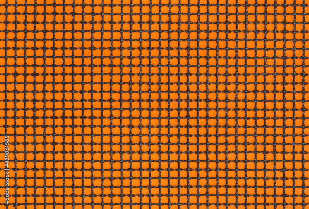 Fototapeta premium Close up of grill mat grid texture. Black mesh on the orange poster board