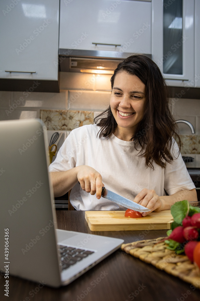 woman cooking checking recipe at laptop woman cooking checking recipe at laptop