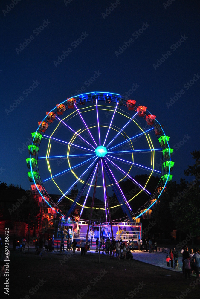Fun fair  at sunset and night big wheel