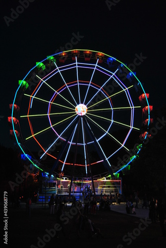 Fun fair at sunset and night big wheel