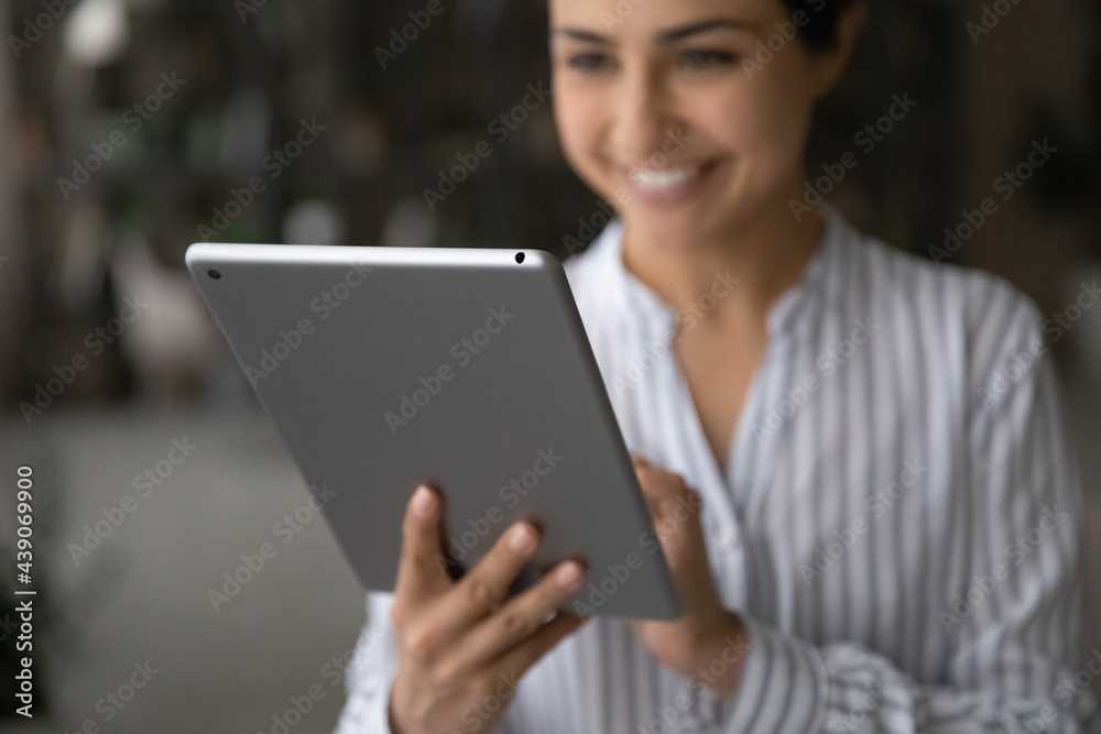 Technologies in life. Close up cropped shot of happy young indian woman user typing message zooming photo image shopping online on modern pad computer screen. Focus on digital tablet in female hands Technologies in life. Close up cropped shot of happy young indian woman user typing message zooming photo image shopping online on modern pad computer screen. Focus on digital tablet in female hands
