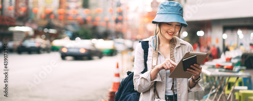 Young adult asian woman traveller using modern tablet using for city lifestyle banner size background. © dodotone