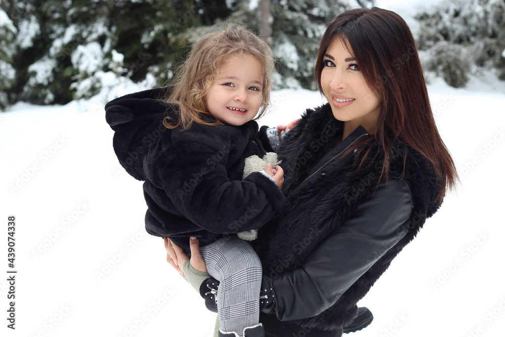 mother and daughter posing on the snow. winter portrait mother and daughter posing on the snow. winter portrait