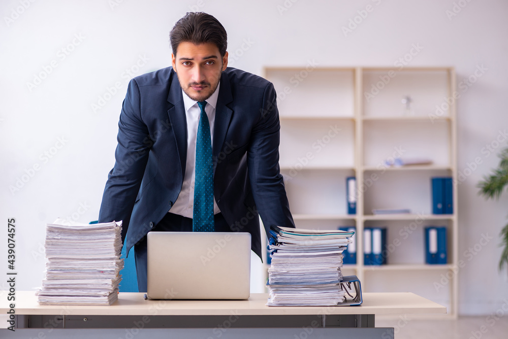 Young businessman employee and too much work in the office