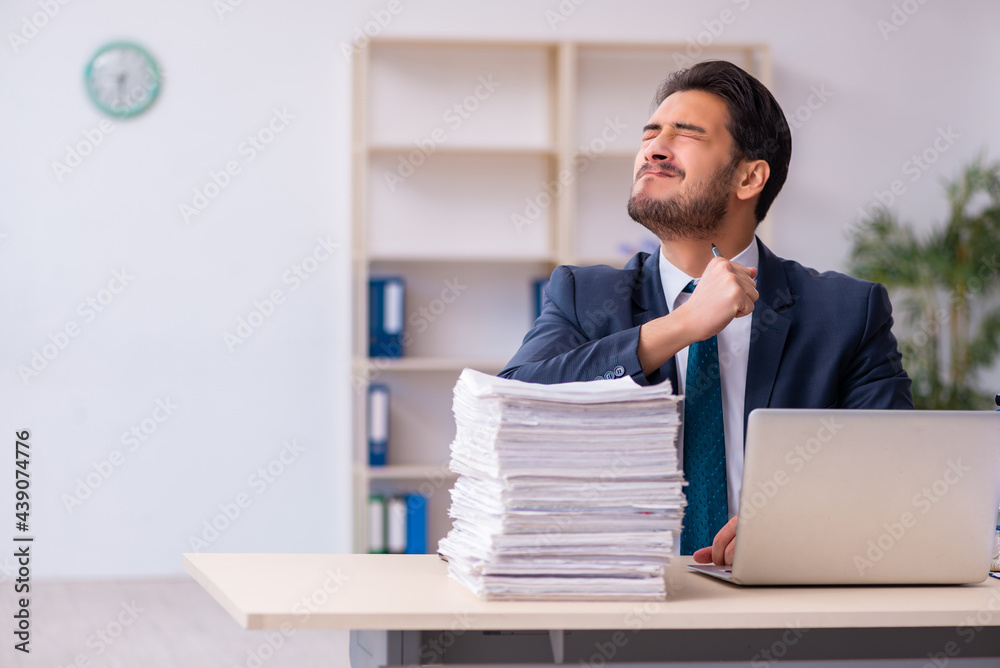 Young businessman employee and too much work in the office Young businessman employee and too much work in the office