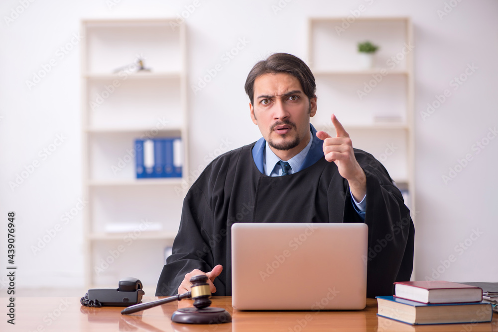 Young male judge working in the courtroom Young male judge working in the courtroom