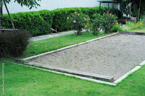Landscape of grass field with petanque court in the garden of backyard photo