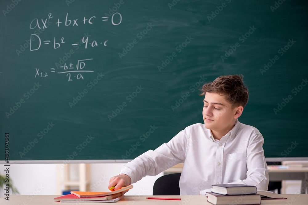 Schoolboy studying math in front of blackboard Schoolboy studying math in front of blackboard